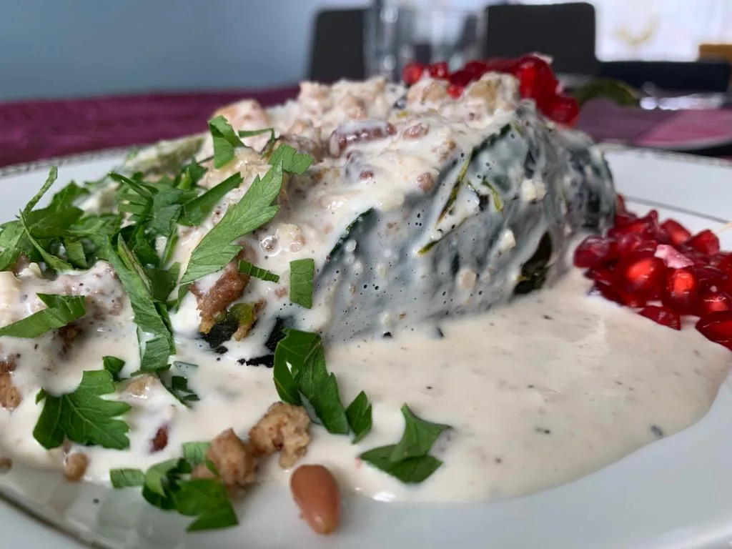 Platillo de chile en nogada con salsa blanca y granada